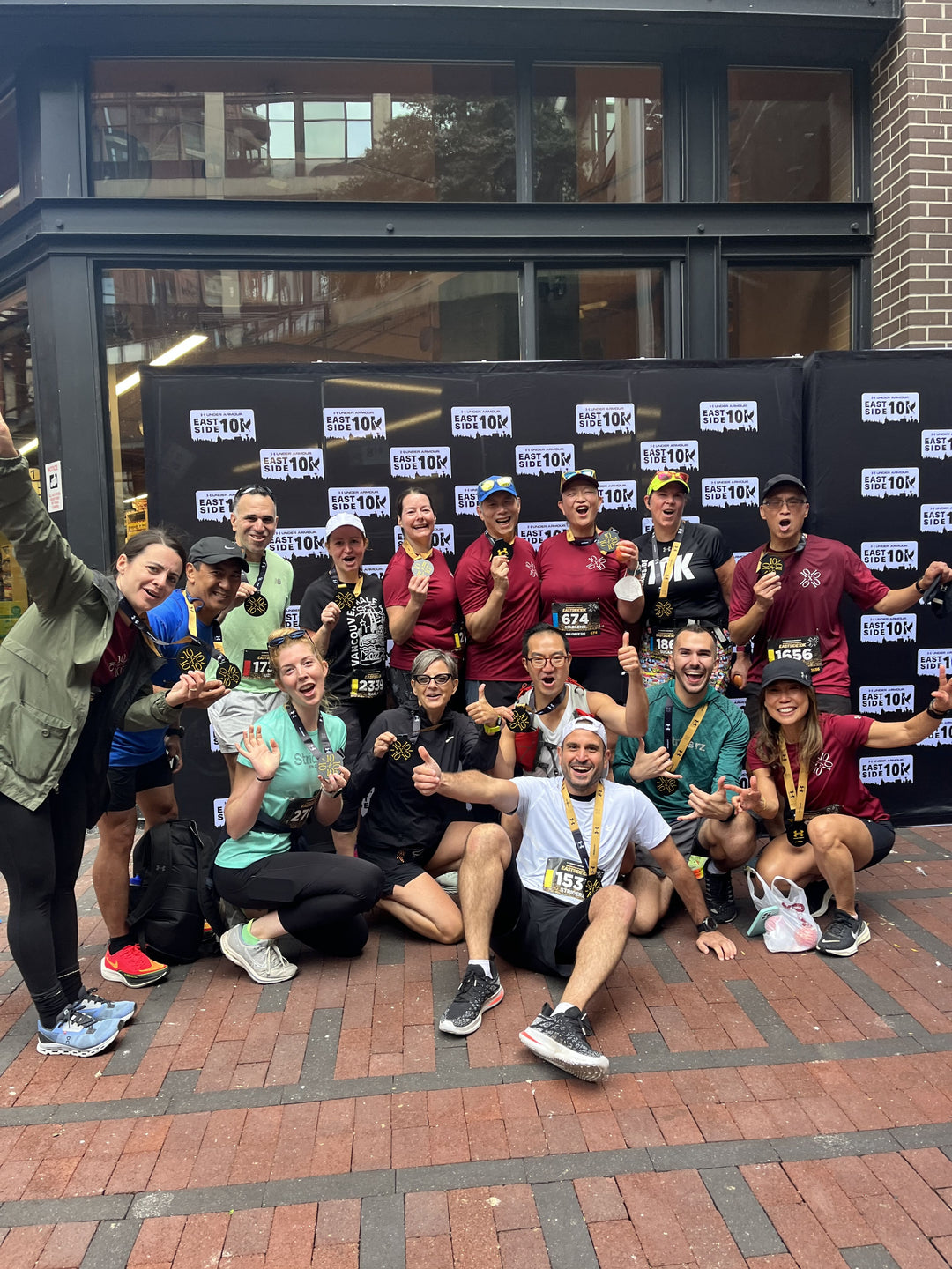 Striderz runners group standing in front of the Eastside10K  banner in Vancouver