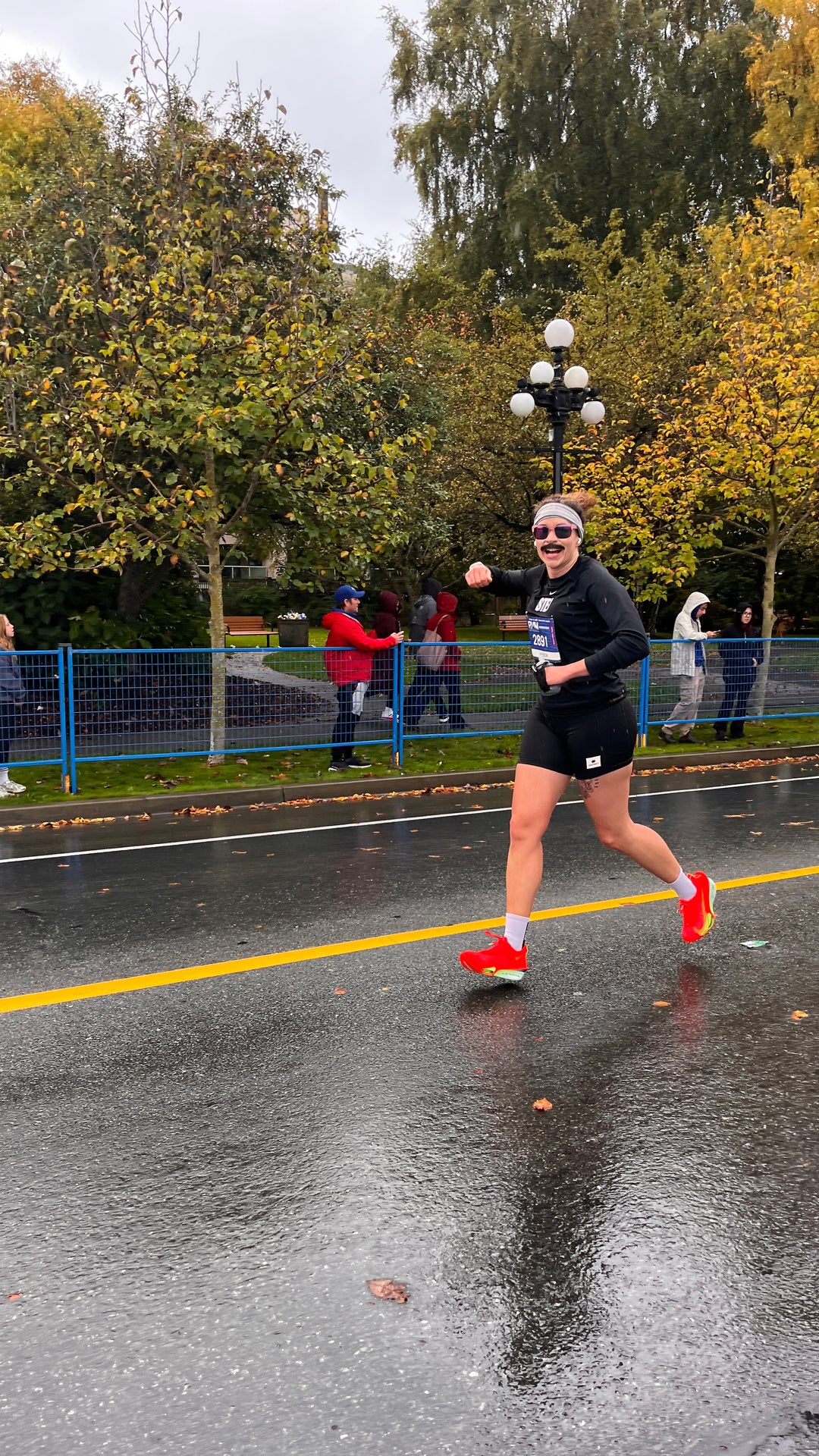 Striderz run club runner waiving at the camera as they pass the finish line