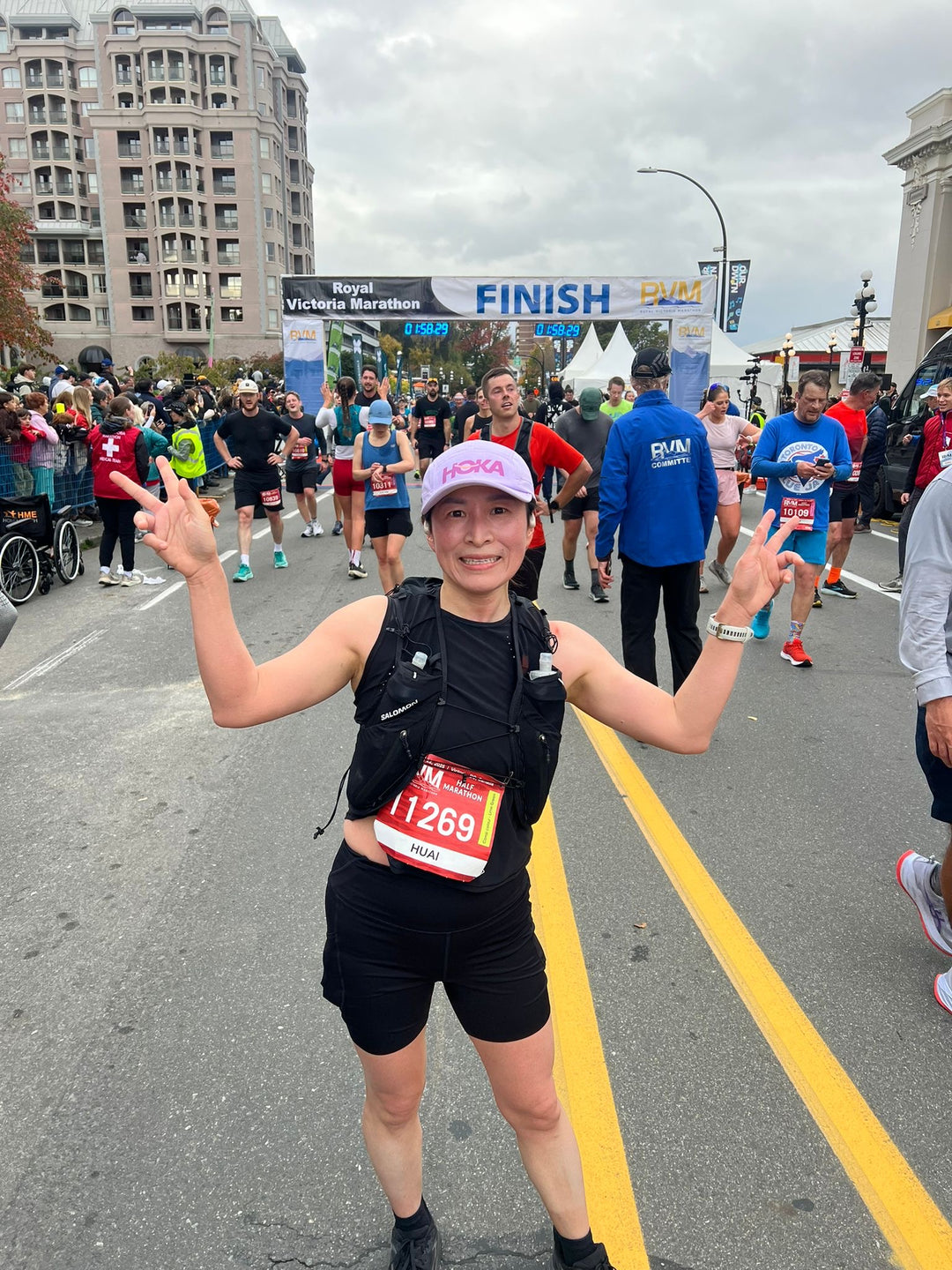 Striderz runner celebrating at the finish line of a marathon with a 'FINISH' sign in the background.